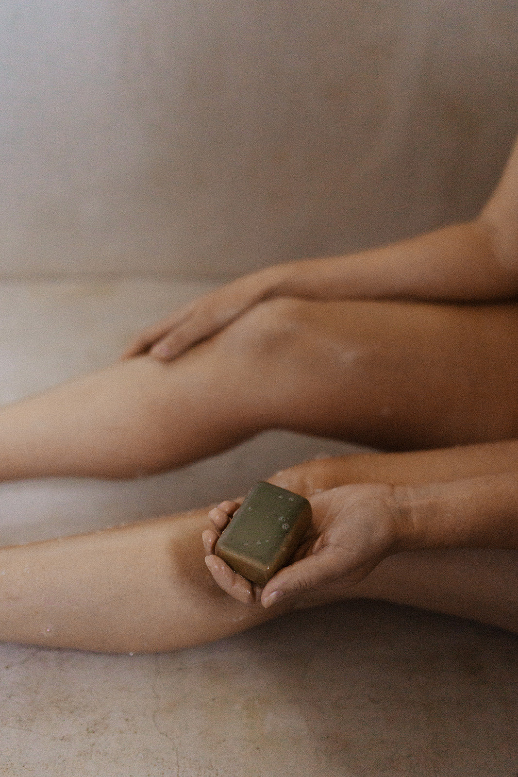 Person in the shower holding an olive oil soap australia